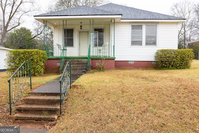 bungalow featuring covered porch and a front yard