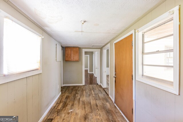 bedroom with ceiling fan, a textured ceiling, dark wood-type flooring, and ornamental molding