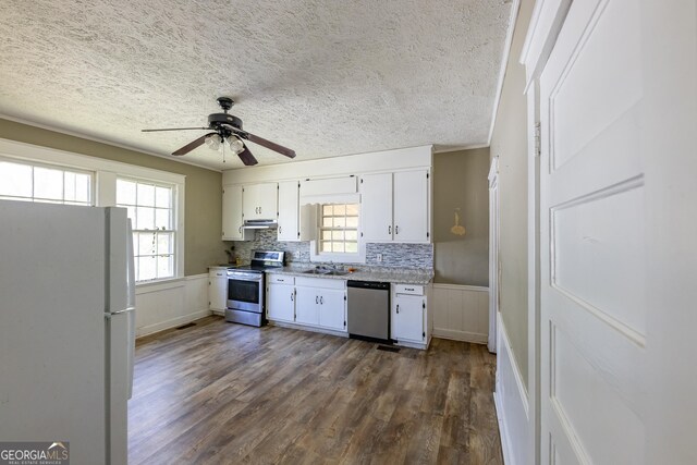 bedroom featuring ceiling fan, dark wood-type flooring, a textured ceiling, and washer / dryer