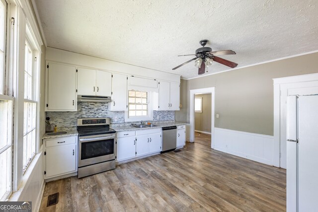 kitchen featuring light hardwood / wood-style flooring, sink, crown molding, stainless steel appliances, and white cabinets