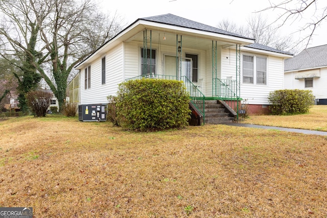 view of front facade with a front lawn and central air condition unit