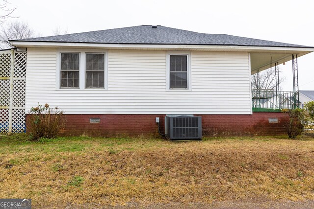 view of home's exterior with central air condition unit and a lawn