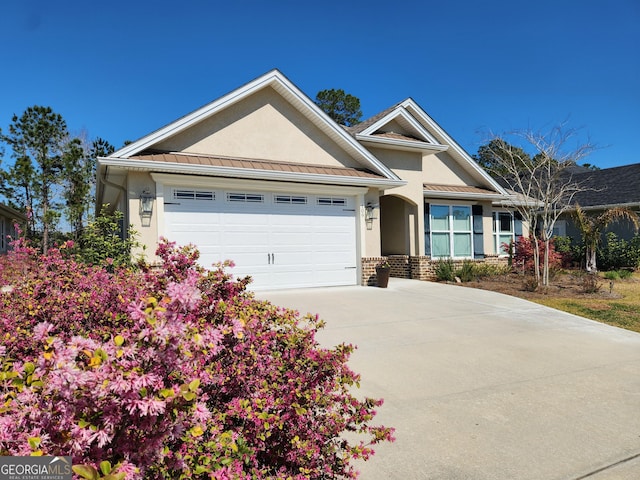 single story home with a standing seam roof, an attached garage, stucco siding, brick siding, and metal roof