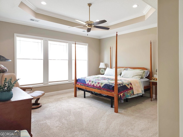 bedroom featuring light carpet, crown molding, a raised ceiling, and ceiling fan