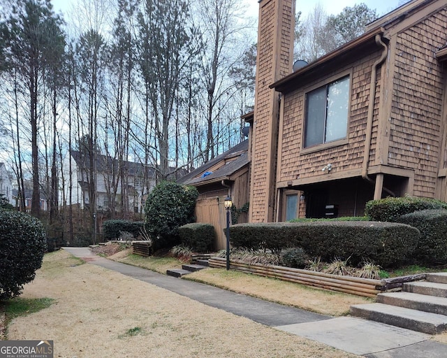 view of home's exterior with a chimney and fence