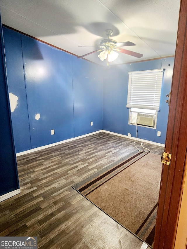 empty room with baseboards, ceiling fan, cooling unit, and dark wood-type flooring