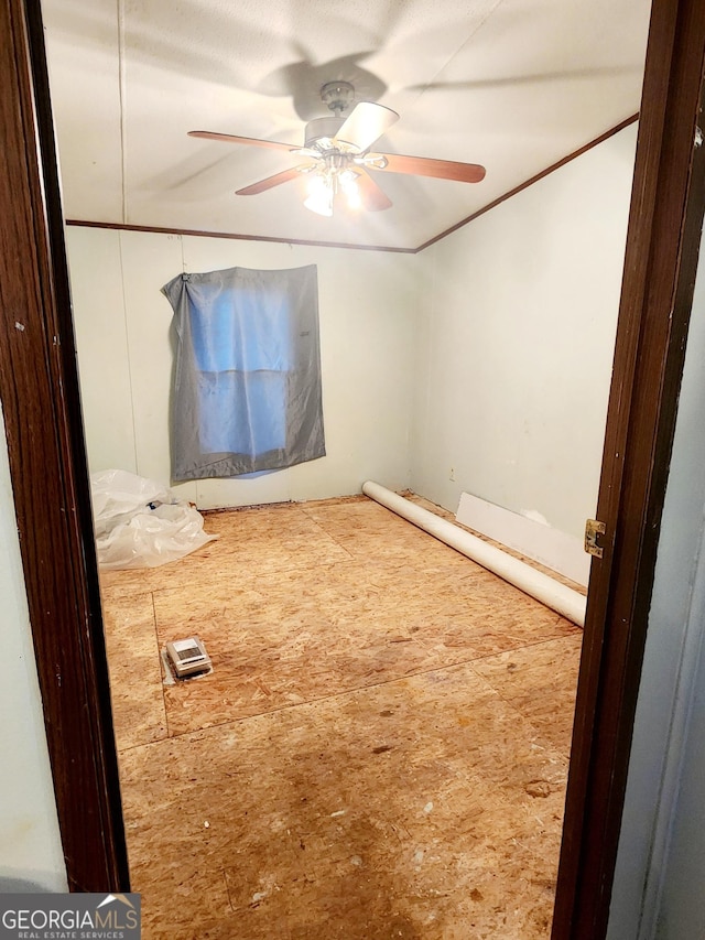 interior space with a ceiling fan and crown molding