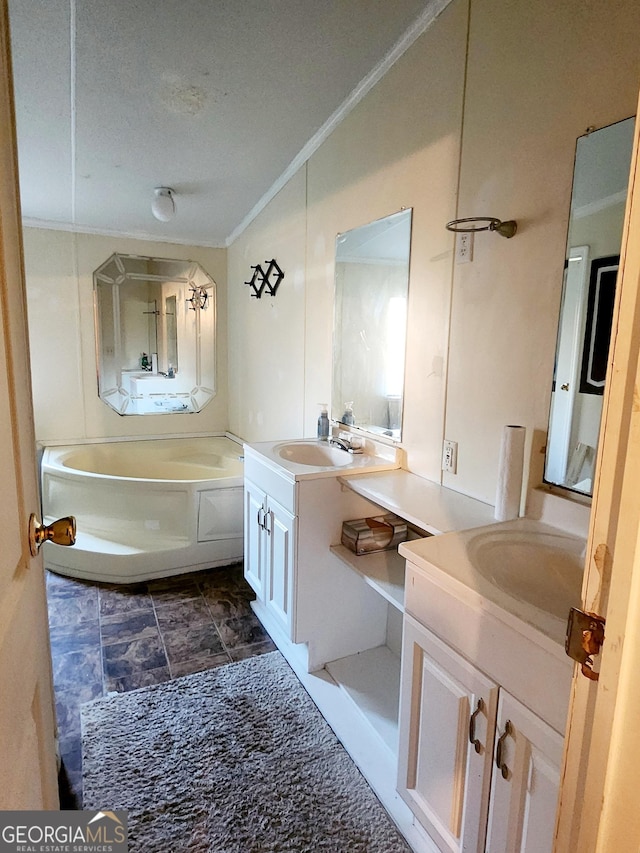 full bathroom featuring crown molding, two vanities, a sink, and a bath