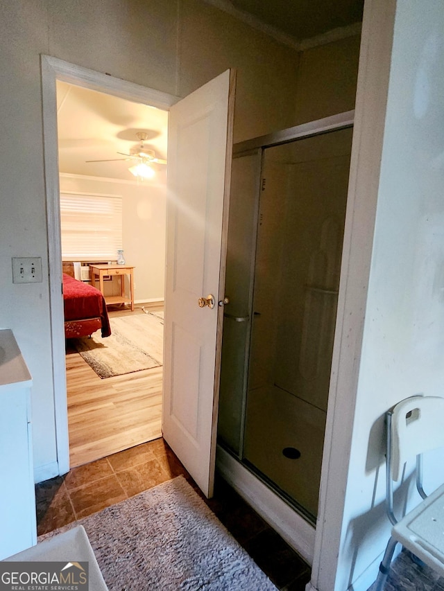 bathroom with ceiling fan, a shower stall, and ensuite bath