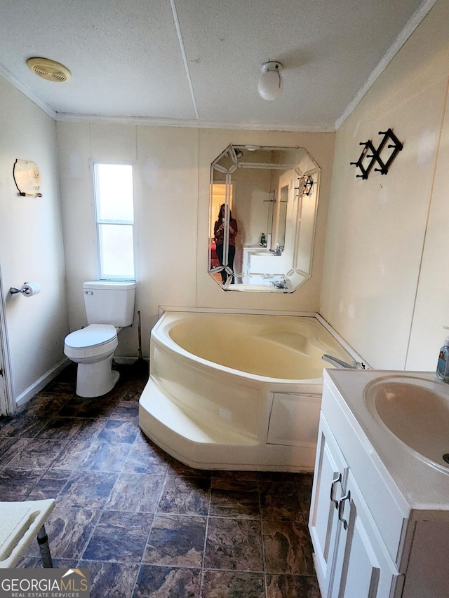 full bathroom featuring a textured ceiling, a garden tub, toilet, vanity, and crown molding