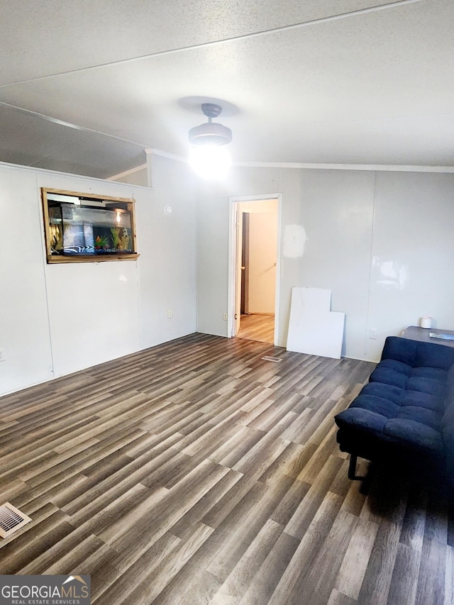 living area featuring ornamental molding, wood finished floors, and visible vents