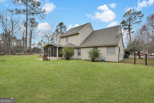 rear view of property featuring a yard and a sunroom