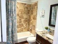 full bathroom with vanity, shower / tub combo, and toilet