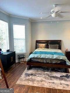 bedroom featuring ornamental molding, dark wood-type flooring, and ceiling fan