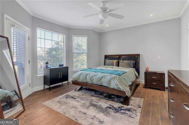 bedroom with ornamental molding, dark hardwood / wood-style floors, access to exterior, and ceiling fan