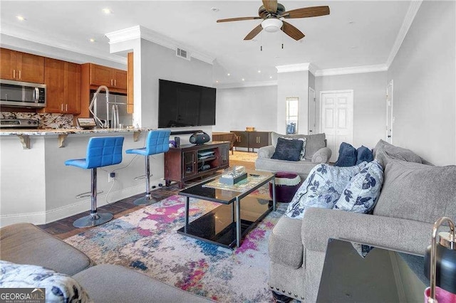 living room featuring crown molding, sink, and ceiling fan