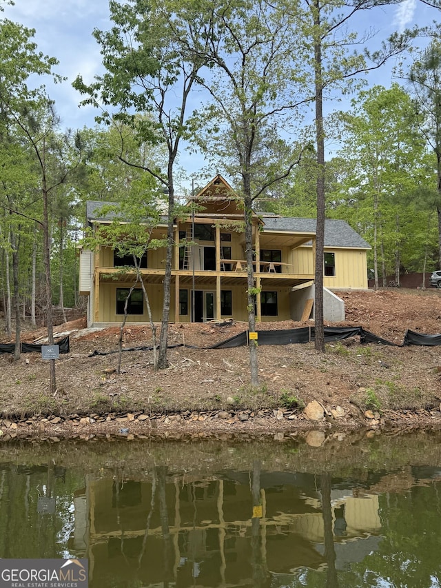 back of property featuring board and batten siding and a water view