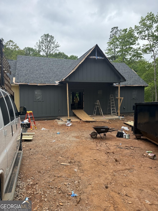 rear view of house with roof with shingles