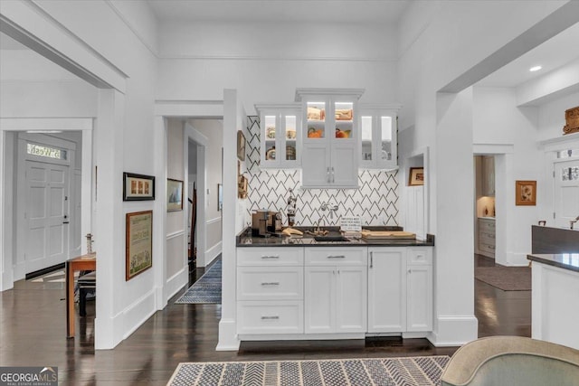 kitchen featuring tasteful backsplash, dark hardwood / wood-style flooring, and white cabinets