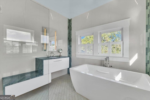 bathroom with tile patterned floors, vanity, and a bathing tub