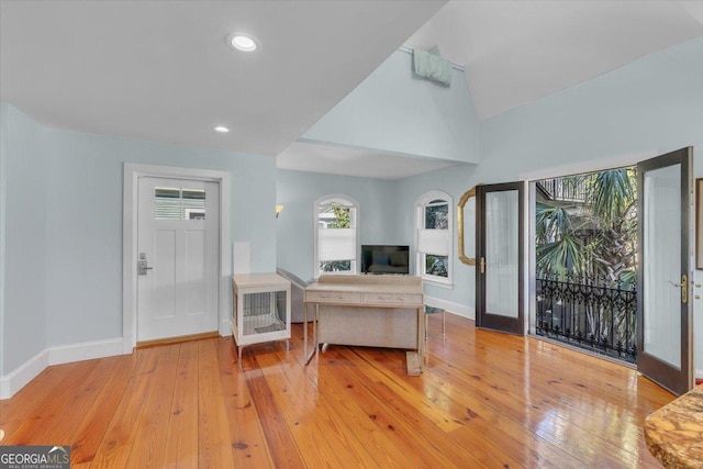 living room featuring lofted ceiling and light hardwood / wood-style floors