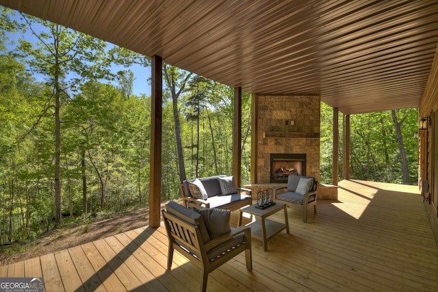 deck with an outdoor living space with a fireplace