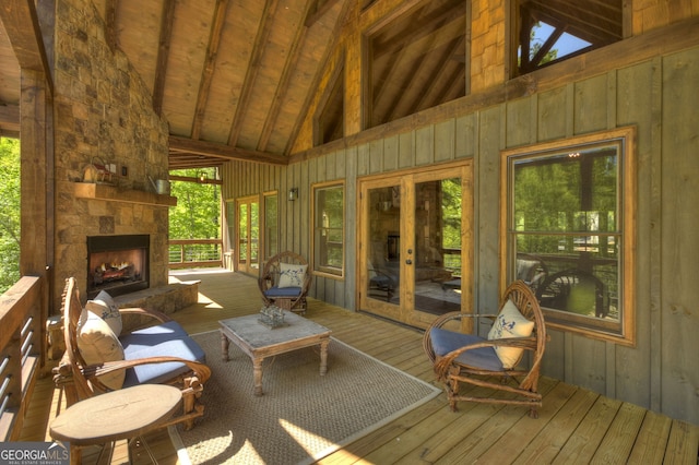 wooden deck featuring a stone fireplace, lofted ceiling with beams, and wooden ceiling