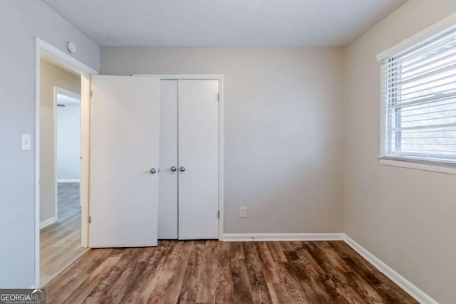 unfurnished bedroom with hardwood / wood-style floors and a closet