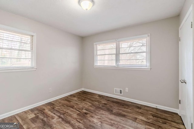 unfurnished room featuring dark wood-type flooring