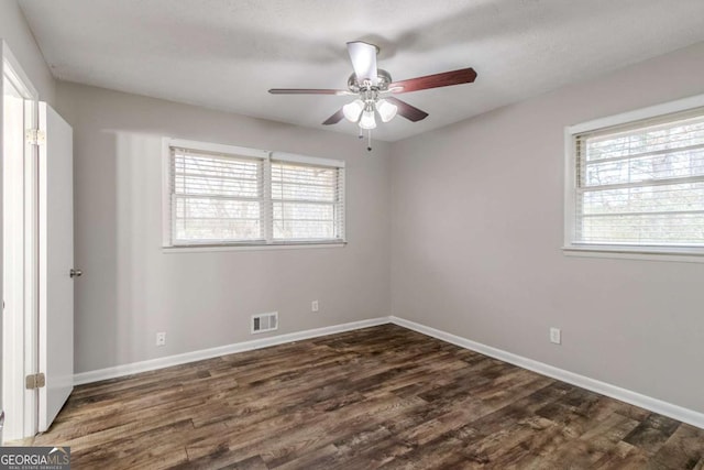 empty room featuring ceiling fan and dark hardwood / wood-style flooring
