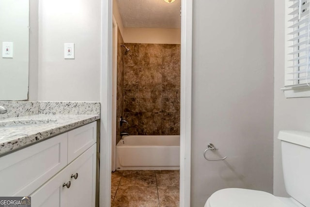 full bathroom featuring tiled shower / bath combo, vanity, toilet, tile patterned floors, and a textured ceiling