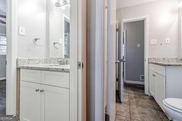 bathroom featuring tile patterned flooring, vanity, and toilet