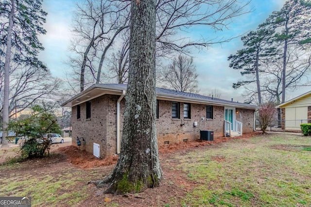 rear view of house featuring a lawn and central air condition unit