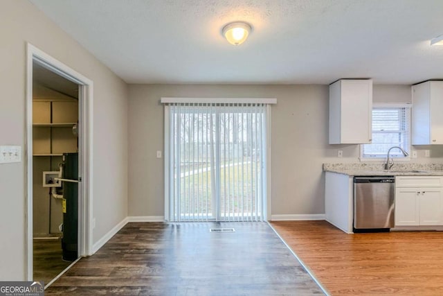 kitchen with sink, stainless steel dishwasher, white cabinets, and light hardwood / wood-style floors
