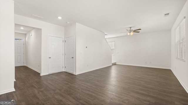 unfurnished living room featuring dark hardwood / wood-style flooring and ceiling fan