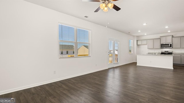 unfurnished living room with ceiling fan, dark hardwood / wood-style flooring, and sink