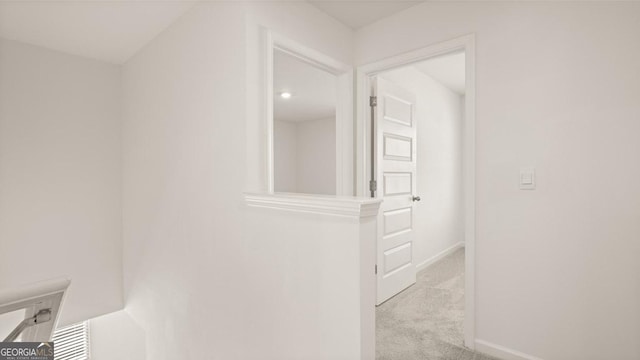 hallway featuring light colored carpet