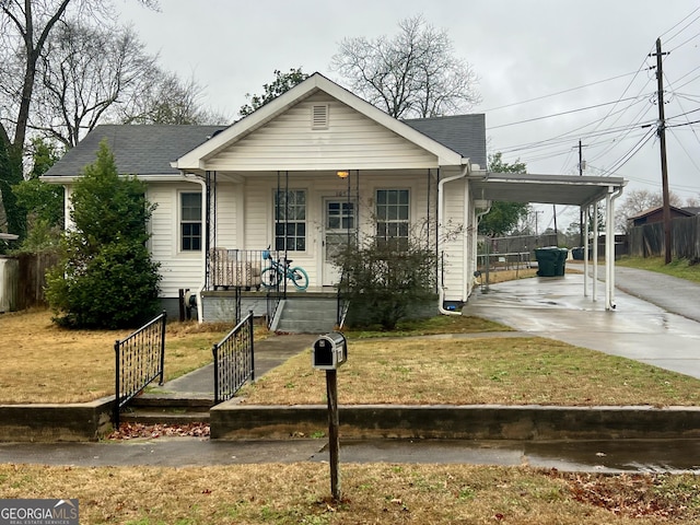 view of front of property featuring a front yard, a carport, and a porch