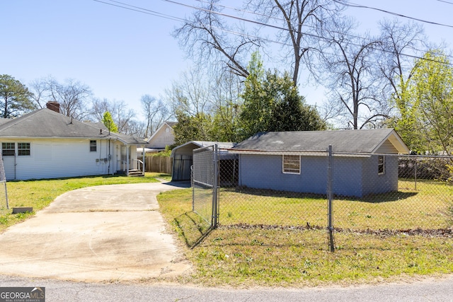 view of side of property featuring a lawn, fence, and driveway