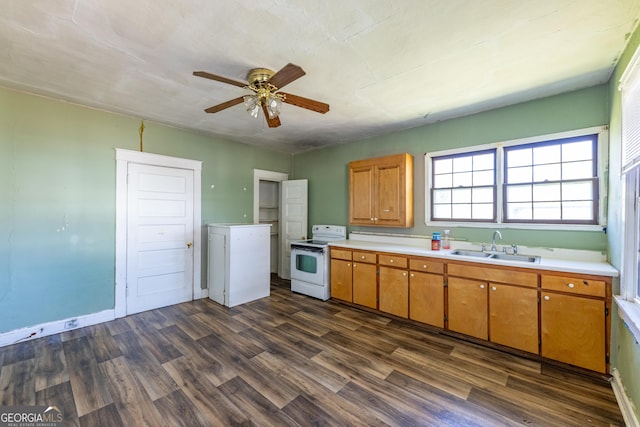 kitchen with a sink, electric range, brown cabinetry, and light countertops