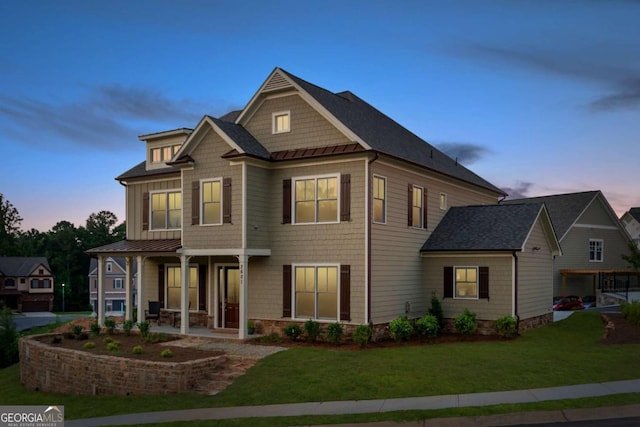 view of front of home with a porch and a lawn