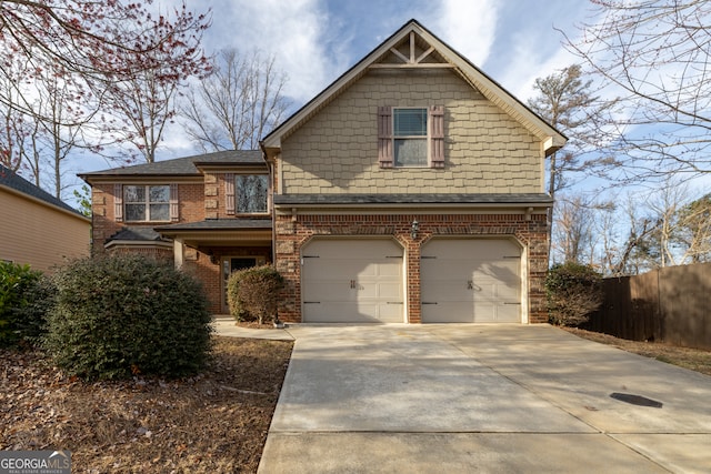 view of front of home featuring a garage, driveway, brick siding, and fence