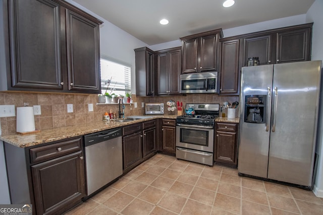 kitchen featuring tasteful backsplash, appliances with stainless steel finishes, sink, and dark brown cabinetry