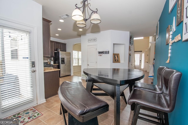 dining room with a chandelier and light tile patterned floors