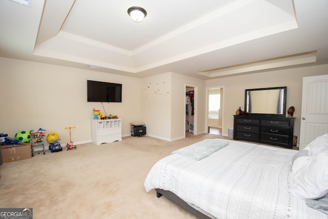 bedroom with carpet floors and a raised ceiling