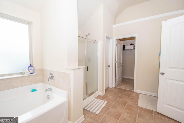 bathroom with lofted ceiling, tile patterned floors, and shower with separate bathtub