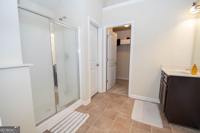 bathroom featuring tile patterned flooring, vanity, and walk in shower