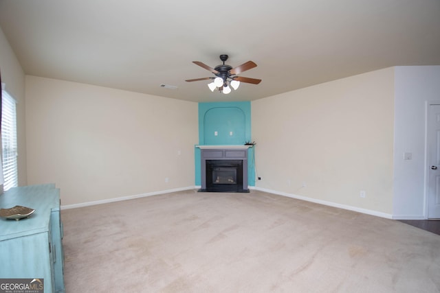 unfurnished living room featuring ceiling fan and light carpet