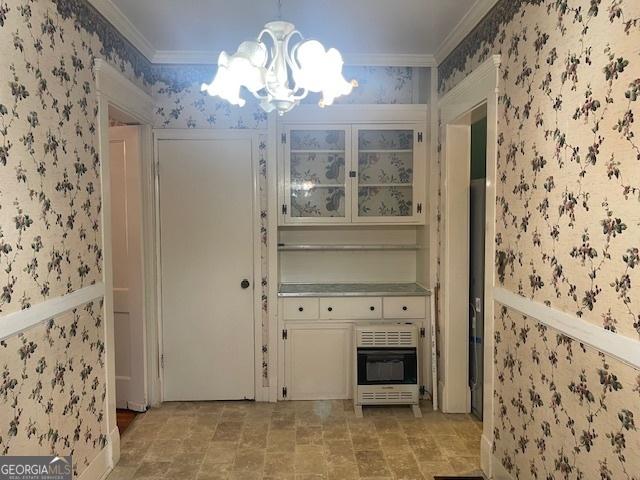 interior space featuring ornamental molding, a wainscoted wall, heating unit, and wallpapered walls