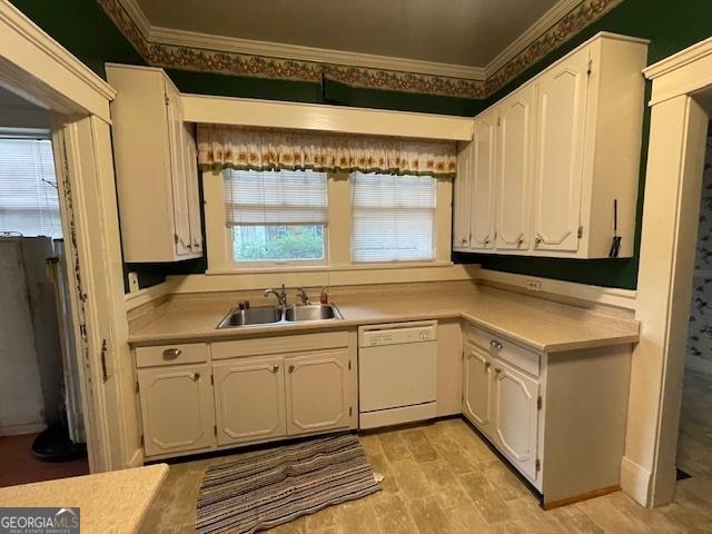 kitchen featuring white cabinets, light countertops, dishwasher, and a sink